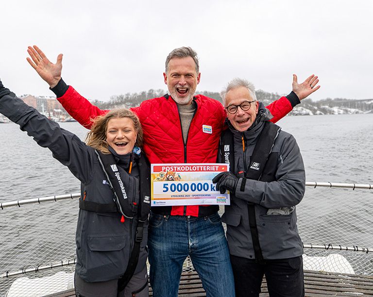 Rickard Sjöberg tillsammans med två av Sportfiskarnas medarbetare, varav en av dem håller i en check.