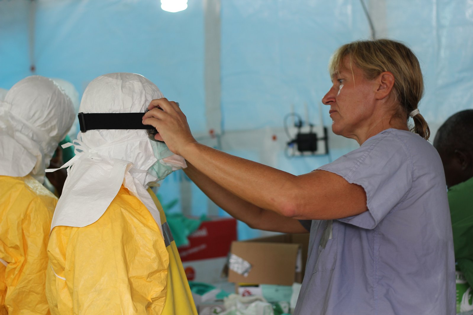 En sjuksköterska rättar till ebolautrustning på en kollega