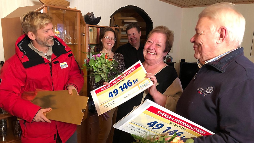 Glada vinnare i Postkodlotteriet från Umeå står med sina vinstcheckar i handen.